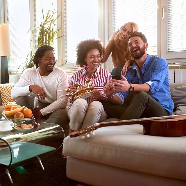 Family sitting on a couch in a room with an Anything Goes Carpet